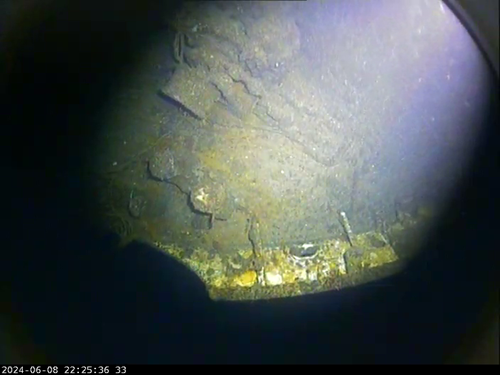 An underwater camera view of the bow of a shipwreck.